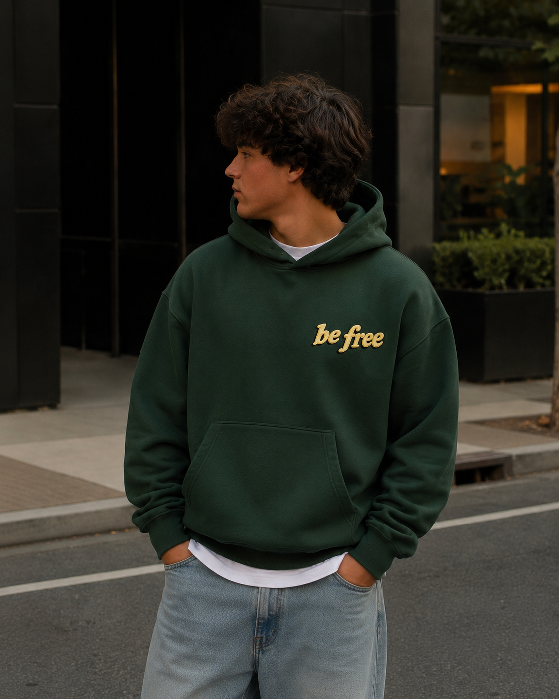 Man wearing Be Free green hoodie on city street