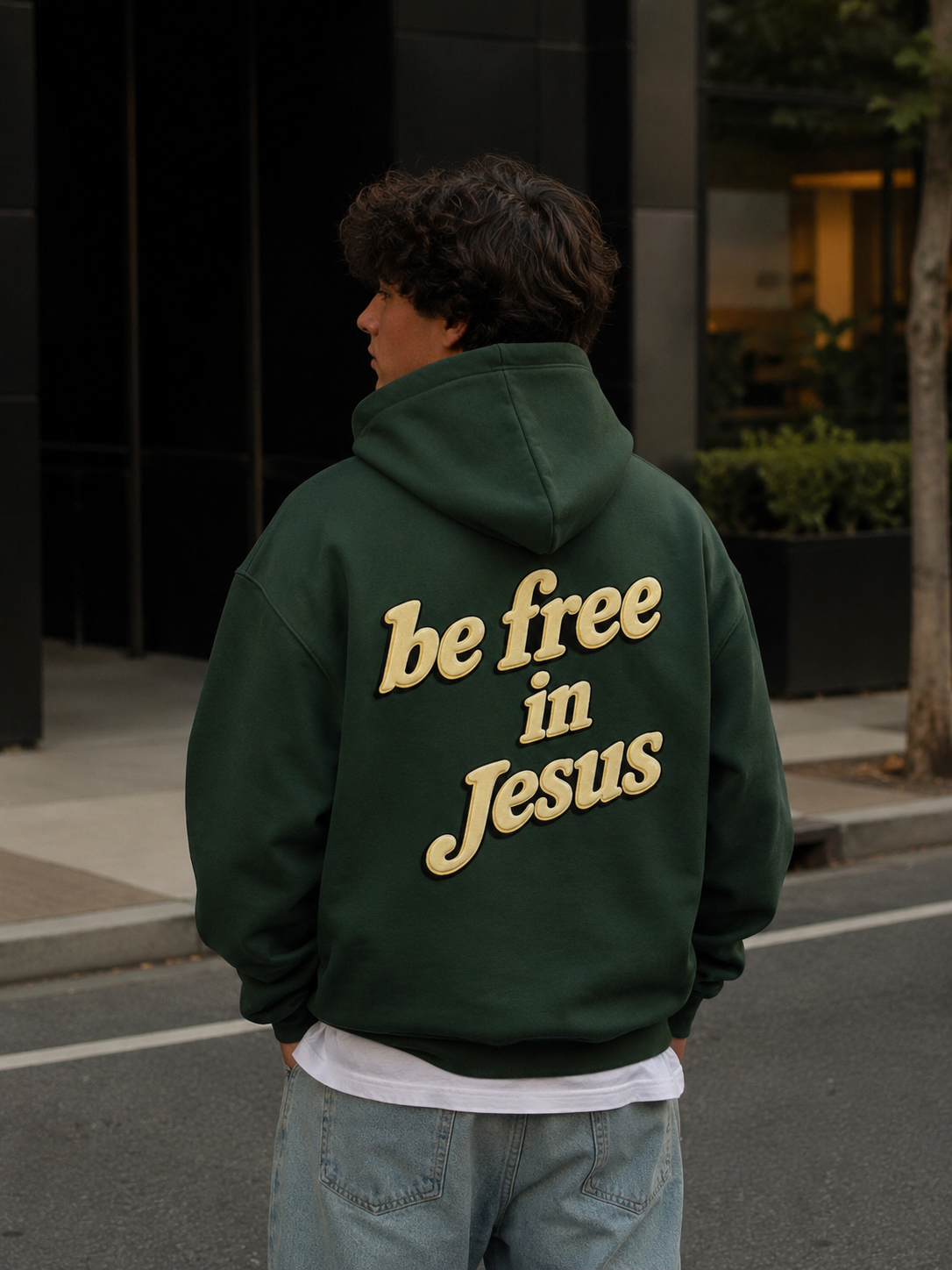 Man wearing Be Free in Jesus hoodie from behind on city street
